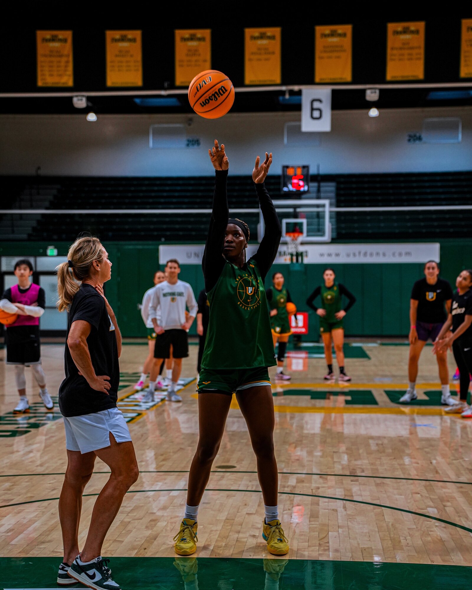 USF Dons player releasing a free throw as the team watches